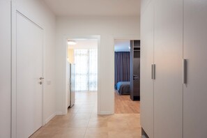 Un couloir menant à une chambre à coucher équipée d’un lit et d’une armoire.