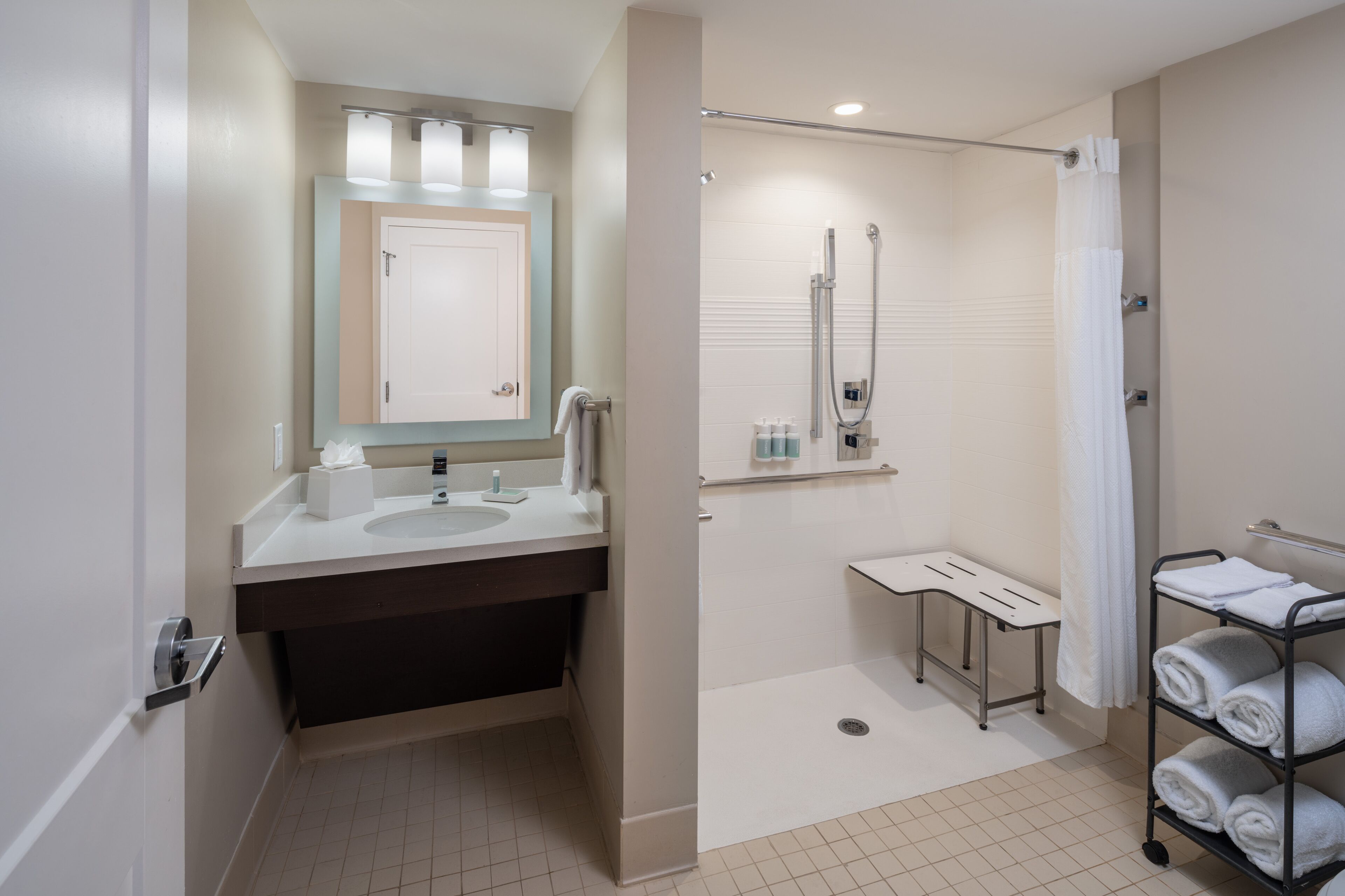 Un bagno moderno con due lavabi, una doccia e un porta asciugamani.