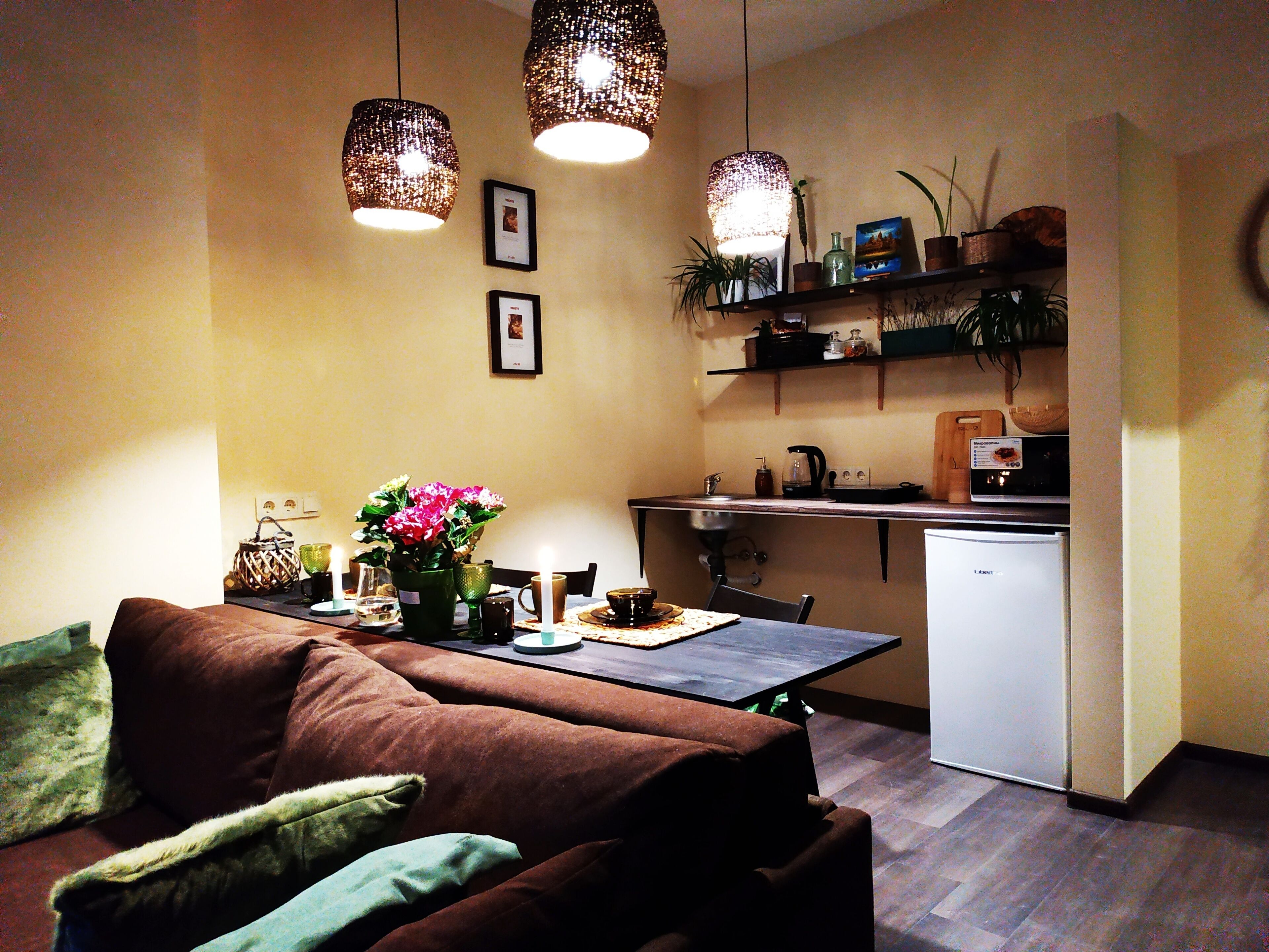 Een gezellige, compacte leefruimte met een bank, eettafel en kitchenette.