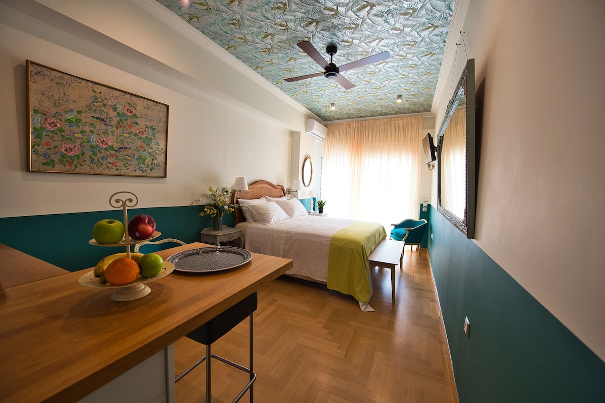 Ein Schlafzimmer mit Bett, Nachttisch und Deckenventilator.