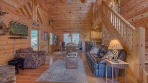 L’intérieur d’une cabane en bois comprend un salon, un coin repas et un escalier.