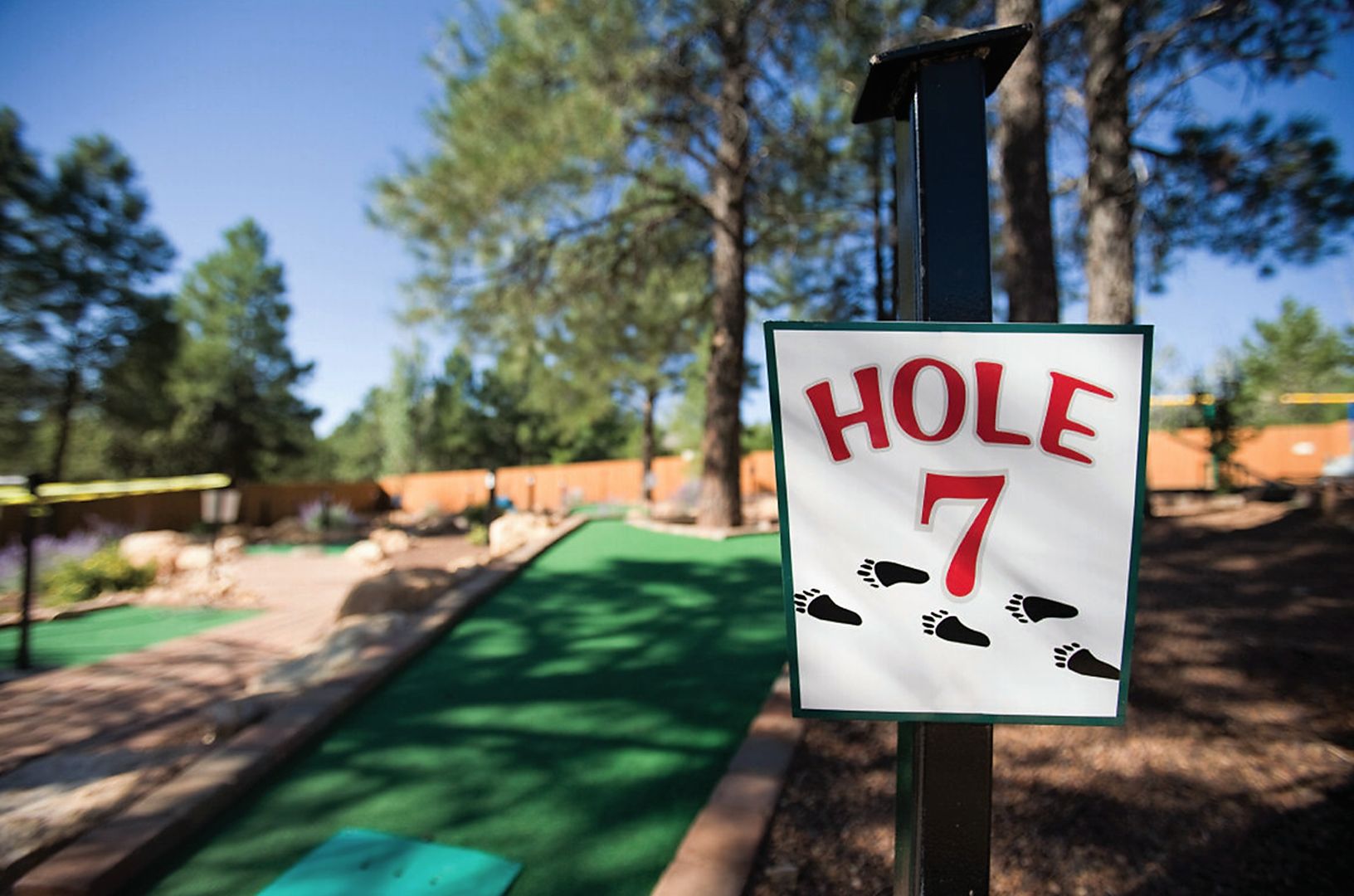 Placa indicando 'HOLE 7' em um campo de golfe.