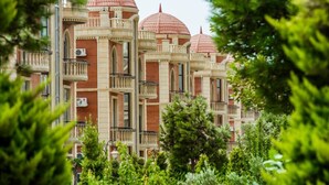 A multi-story building with a distinctive architectural style, featuring red domes and balconies. - Golden Moon Baku (Baku)