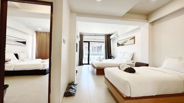 A hotel room with two beds, a large mirror, and a view of the city through the window. - Key Hotel at Old City Center (Chiang Mai)