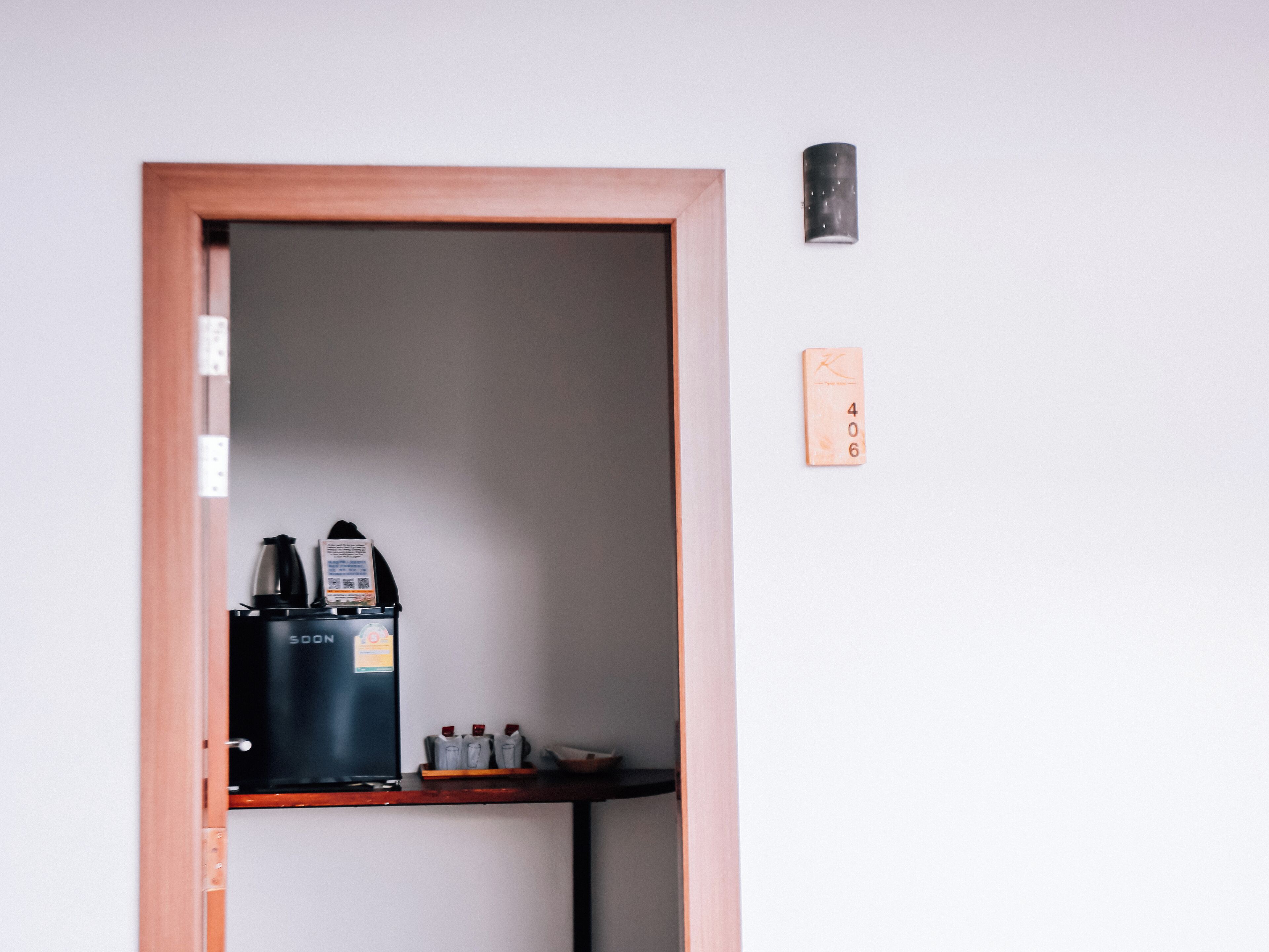 A door with a coffee machine and a small shelf with items.
