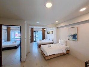 Habitación de hotel con dos camas, un ventanal con cortinas, un cuadro en la pared y vistas a la ciudad.