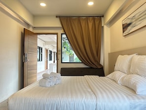 A hotel room with a bed, a window with curtains, a door, and a painting on the wall. - Key Hotel at Old City Center (Chiang Mai)