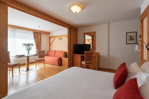 A hotel room with a bed, a desk, a chair, a television, and a window with curtains. - Carlo Magno Hotel Spa Resort (Pinzolo)