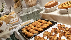 A buffet with various baked goods including croissants, a cake, and pastries. - Carlo Magno Hotel Spa Resort (Pinzolo)