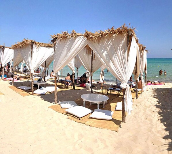 Playa privada, arena blanca, sillas reclinables de playa, sombrillas