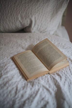 An open book on a textured white surface. - Glorious 2 Bedroom Apartment (London)