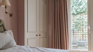 A bedroom with a bed, a door, and a view of the outdoors. - Glorious 2 Bedroom Apartment (London)