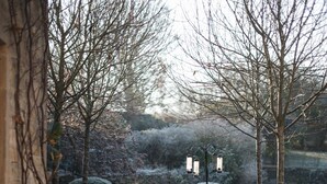 A garden pathway with a lantern post and spherical bushes. - Glorious 2 Bedroom Apartment (London)