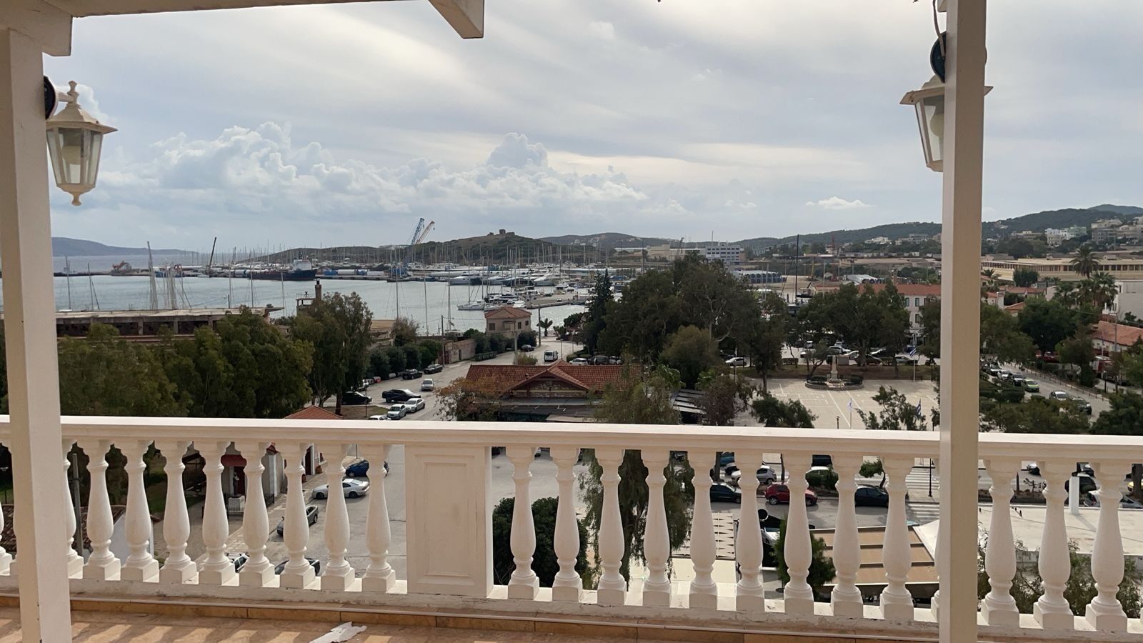 Ein Balkon mit Blick auf einen Yachthafen, Gebäude und eine Brücke in der Ferne.