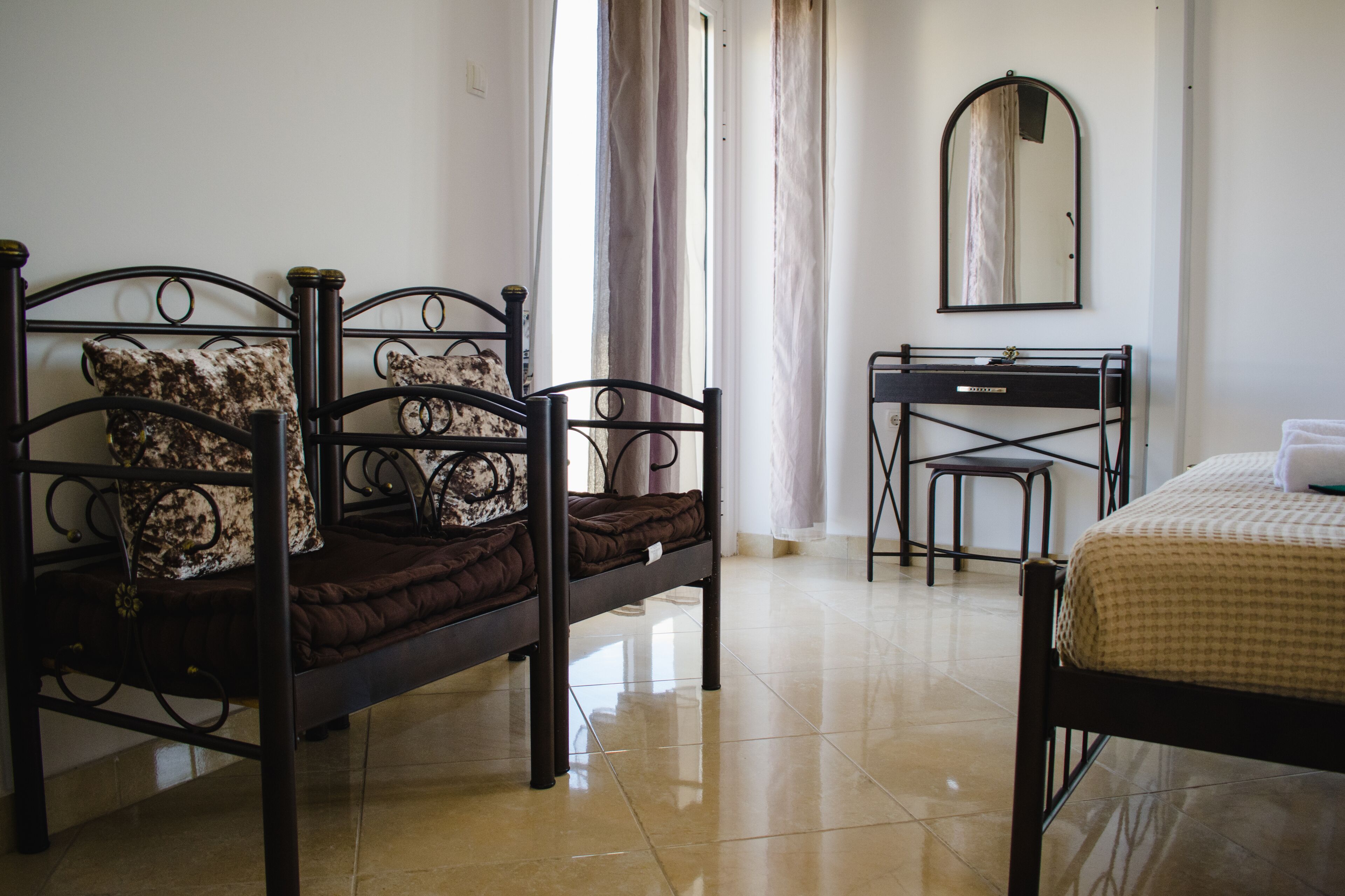 A bedroom with a bed, a desk, and a chair.