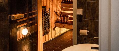 A modern bathroom with a large bathtub, a glass shower enclosure, and a wooden vanity.