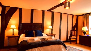 Una camera da letto con un letto grande, due comodini con lampade, una sedia e un tappeto decorato.