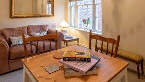 A cozy living room with a wooden table, a sofa, a chair, and a large mirror on the wall. - Apt 2, 71 Micklegate, YORK (York)