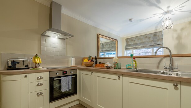 A kitchen with white cabinets, a built-in oven, a sink, and a window with blinds. - Apt 2, 71 Micklegate, YORK (York)