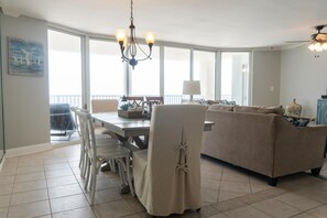 Un salón espacioso con un sofá grande, una mesa de comedor y una araña.