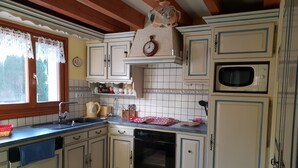 Une cuisine avec des armoires blanches, un évier, une cuisinière et un four à micro-ondes.