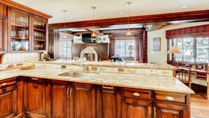 A spacious kitchen with a large island, wooden cabinetry, and a view of the outdoors. - 1-#28 One Willow Bridge 3BD (Vail)