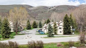 Un barrio residencial con casas, un camino de entrada y montañas al fondo.