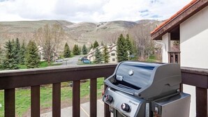 Un balcón con una parrilla que da a una zona residencial con casas y árboles.