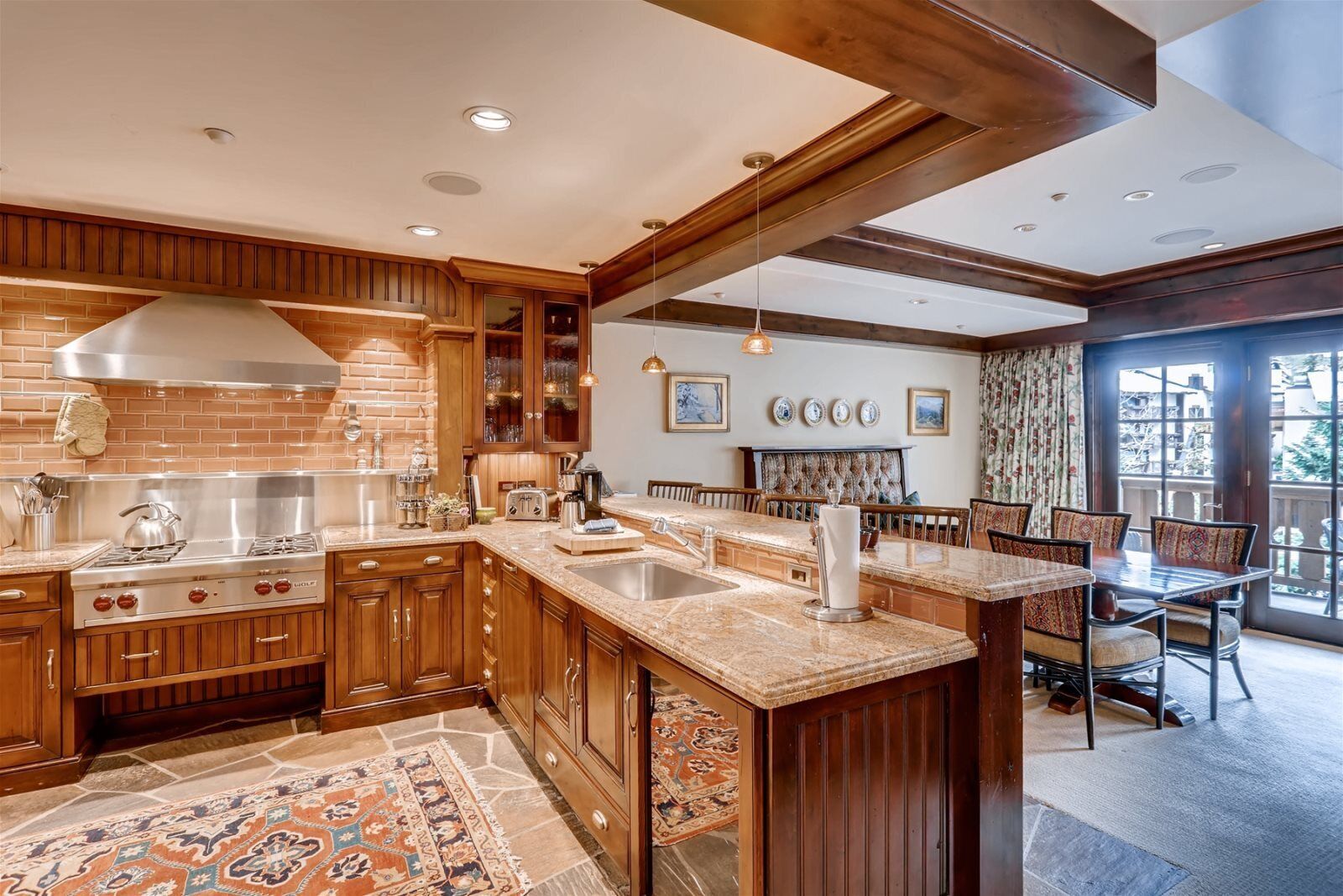 Una cocina amplia con armarios de madera, una isla grande y un comedor con vistas.