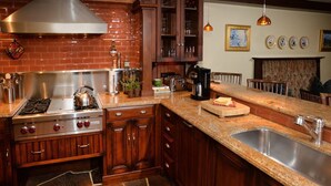 A kitchen with a gas stove, wooden cabinets, a granite countertop, and a built-in sink. - Vail VLG One Willow 2bd-joh1 (Vail)