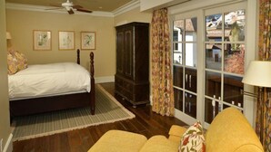 A bedroom with a bed, a dresser, a chair, and a view through a glass door. - Vail VLG One Willow 2bd-joh1 (Vail)