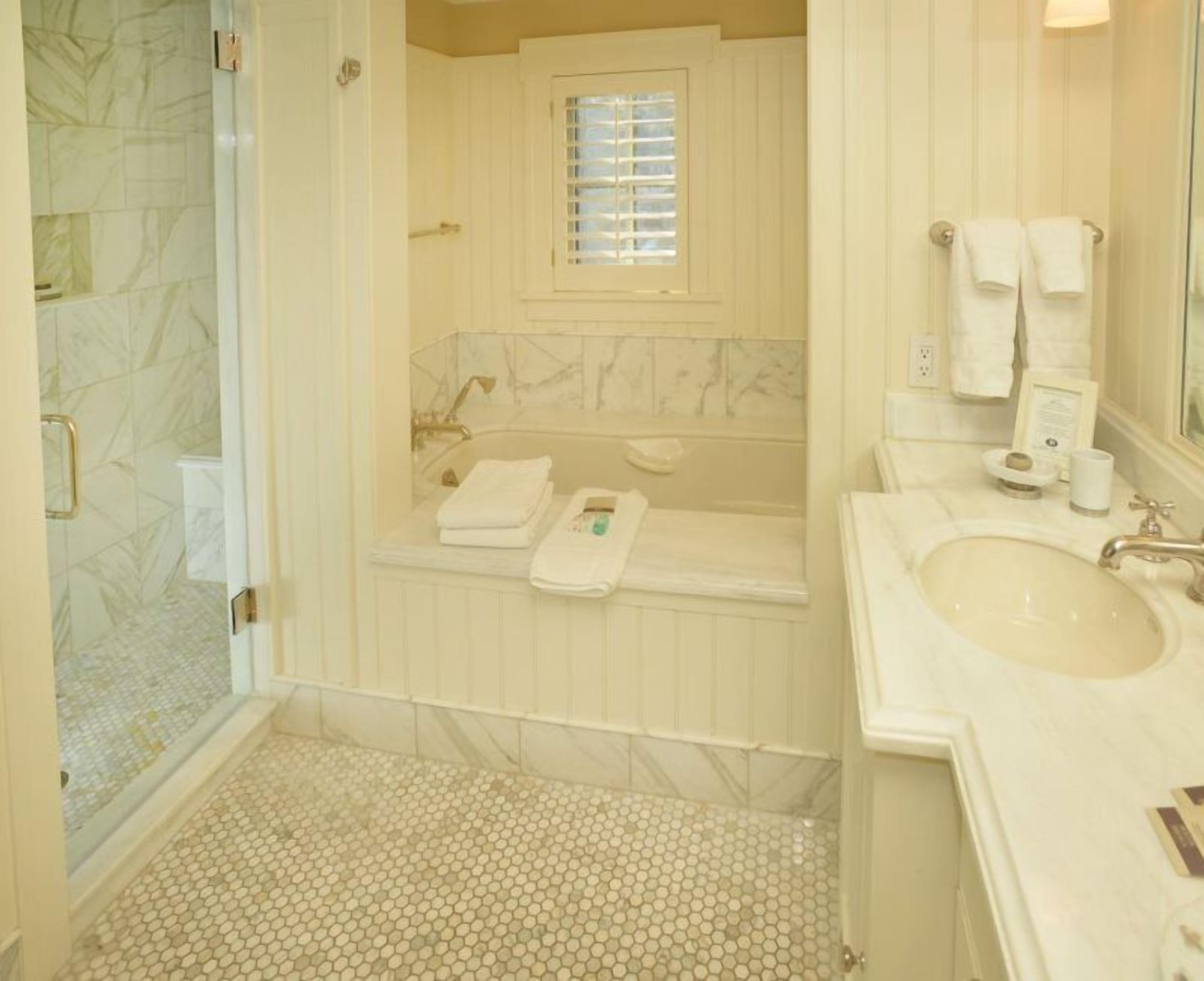 Un baño con ducha, bañera y lavamanos.