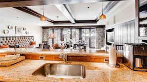 A modern kitchen with a built-in island, stainless steel sink, and a coffee maker.