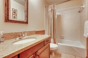 A bathroom with a marble countertop, a sink, a toilet, and a bathtub. - 2-385 Gore Creek dr Vorlaufer 201 (Vail)