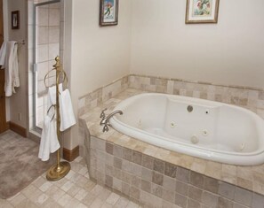A bathroom with a freestanding bathtub, a towel rack, and a tiled floor. - 1-arrowhead 45 River Dance Way 5 bed (Edwards)