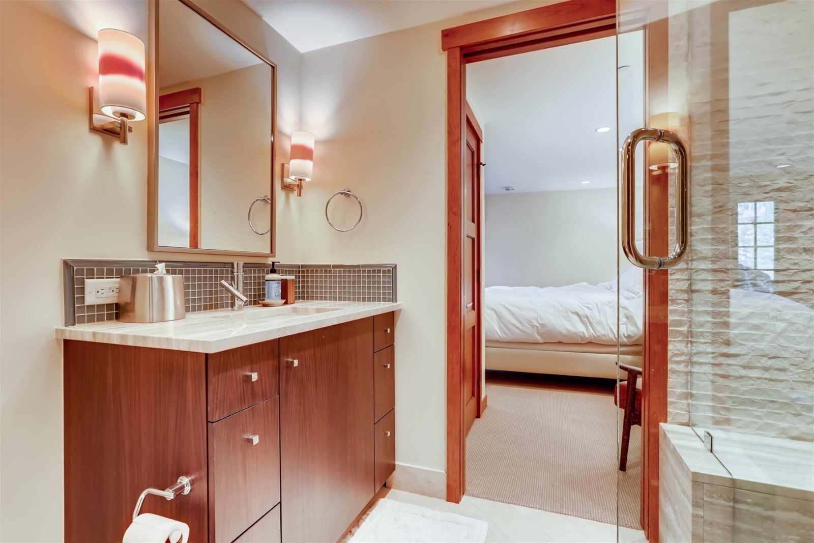 Une salle de bain moderne avec un meuble-lavabo à deux vasques, un grand miroir et un espace douche.