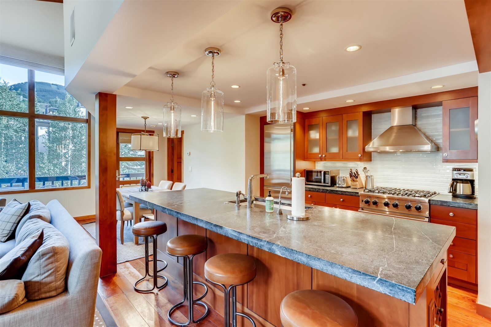 Una cocina moderna con una isla grande, electrodomésticos de acero inoxidable y armarios de madera.