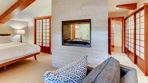 A bedroom with a bed, a bedside table, a lamp, a window with a view of the bathroom, and traditional Japanese sliding doors. - 1-385 Gore Creek Dr. Vorlaufer #303 (Vail)