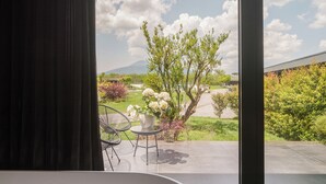 A modern room with a large window, a white bathtub, and two chairs. - Secret Garden (Palma Campania)