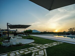 A modern outdoor area with a pool, seating, and a view of the sunset. - Secret Garden (Palma Campania)