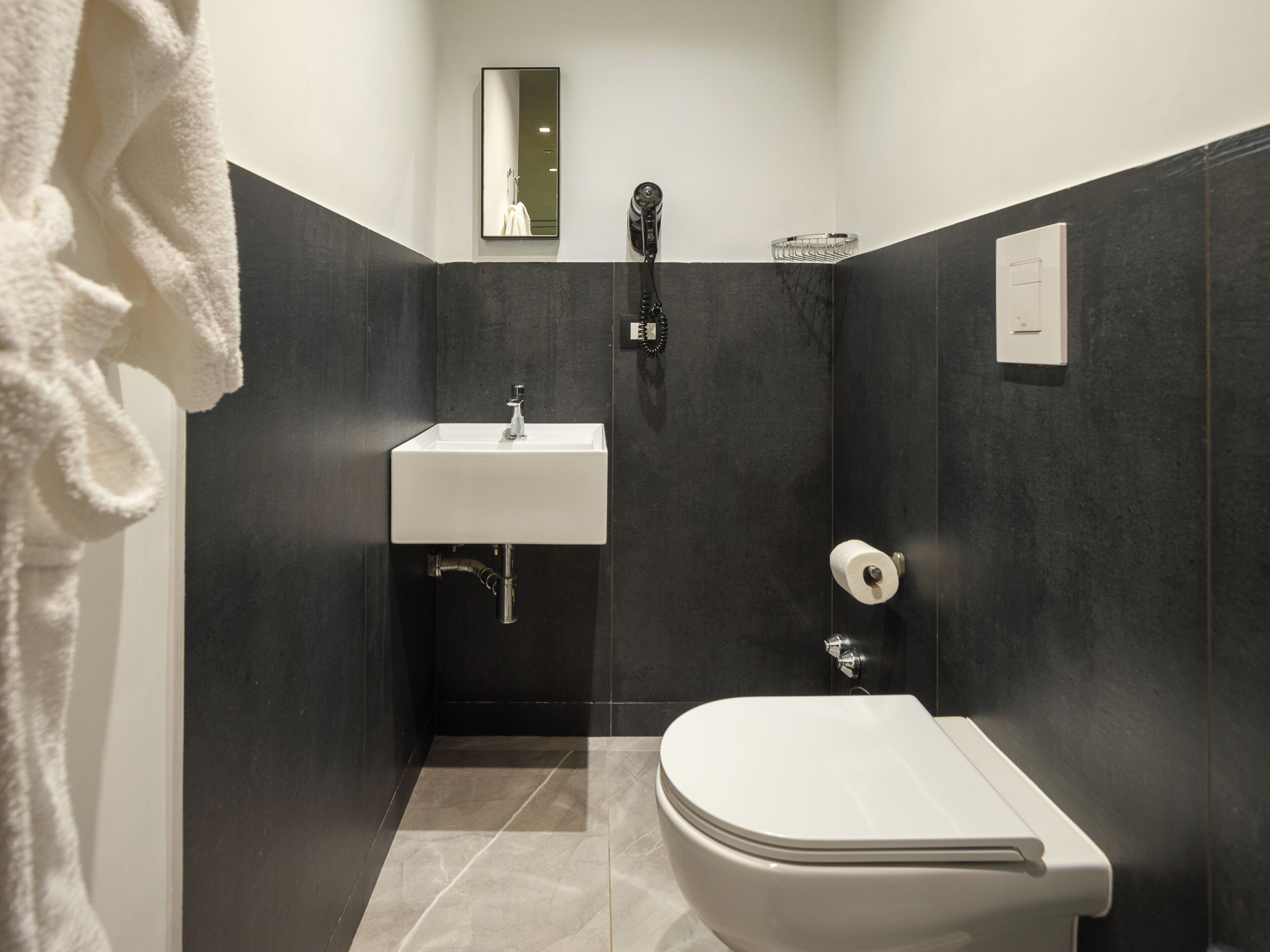 Ein modernes Badezimmer mit Waschbecken, Toilette und Handtuchhalter.