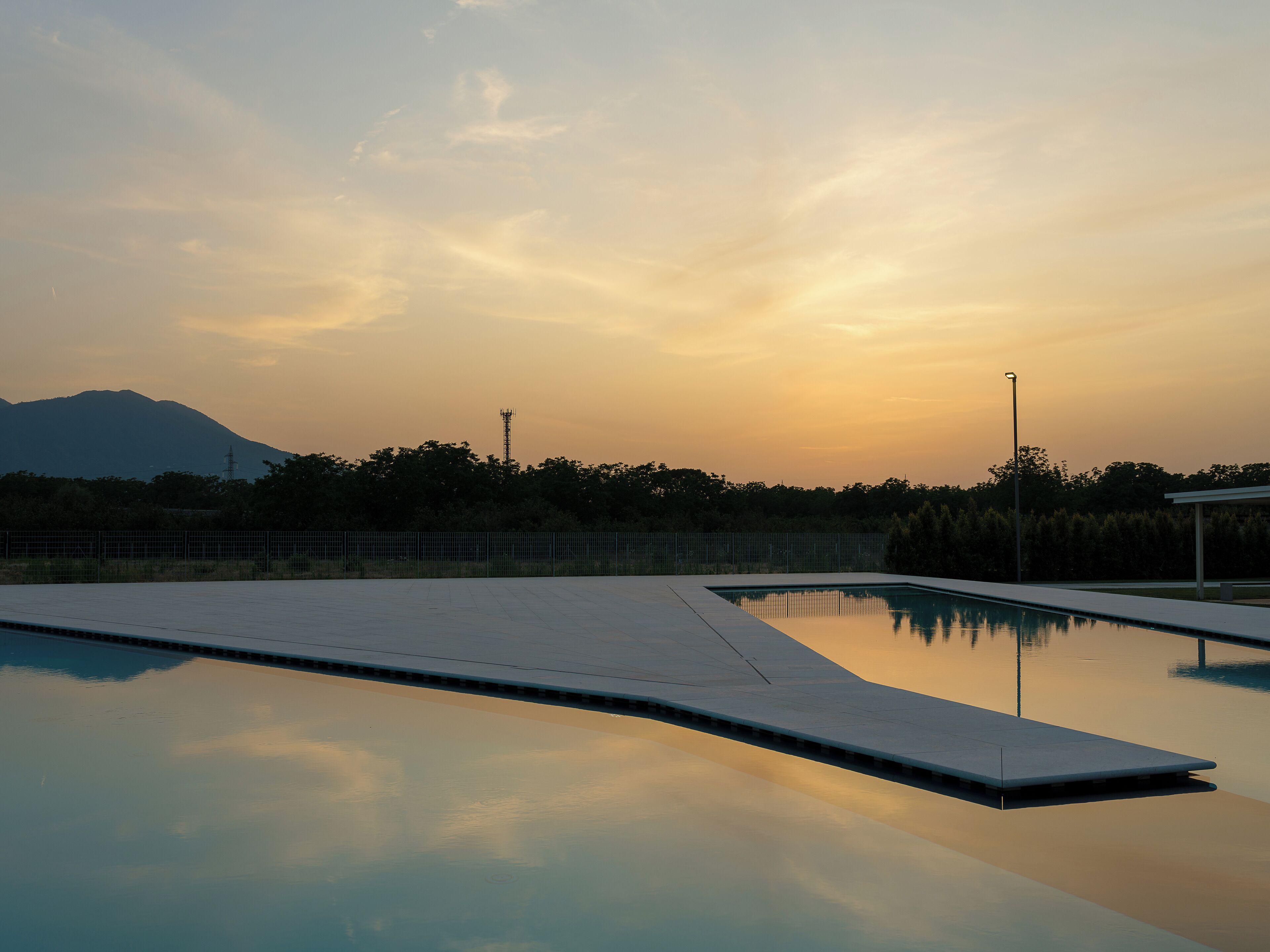 Ein Schwimmbecken mit freiem Blick auf die umliegende Landschaft und einem Berg im Hintergrund.