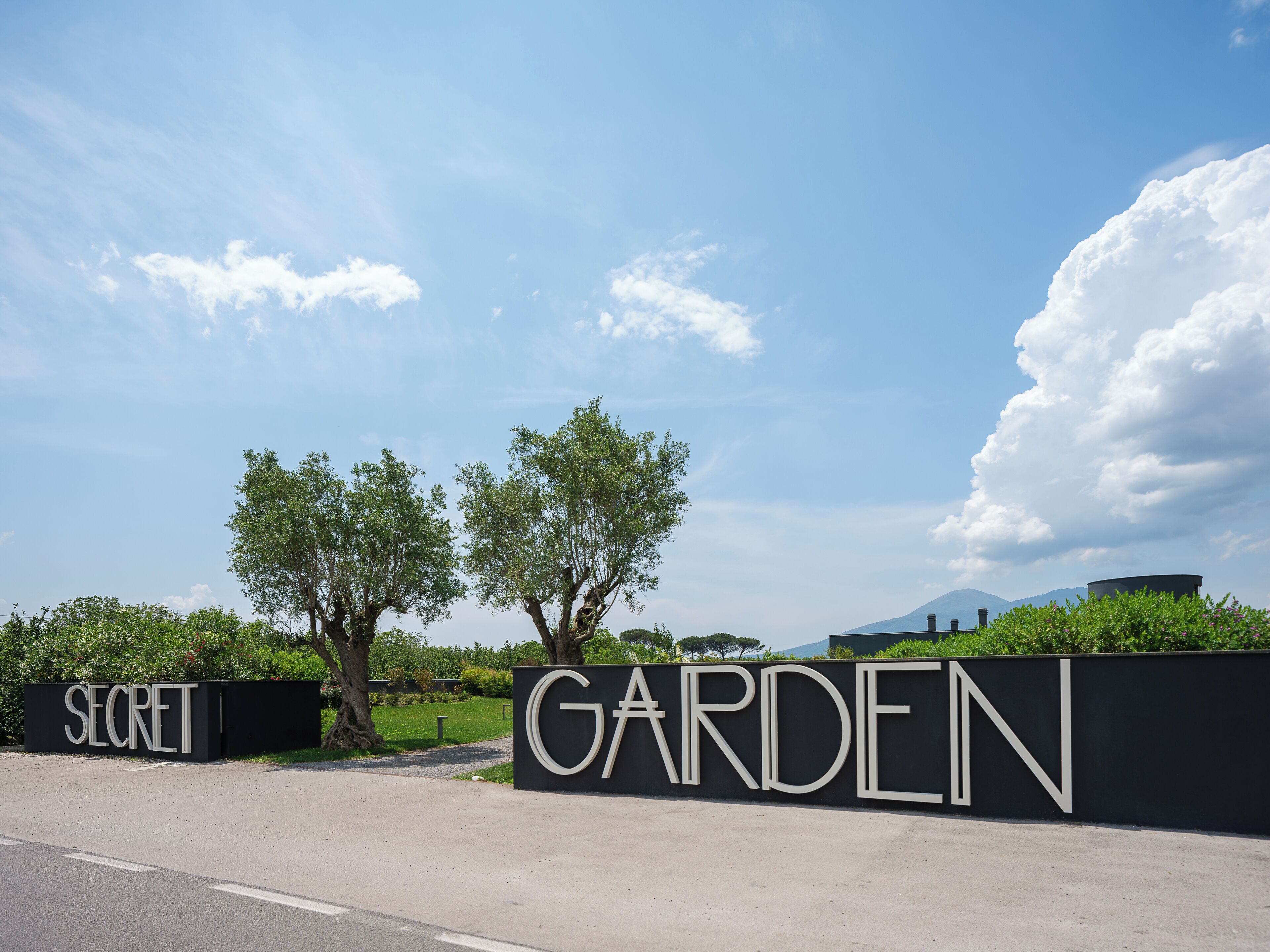 A large black wall with the words "SECRET GARDEN" in white letters.
