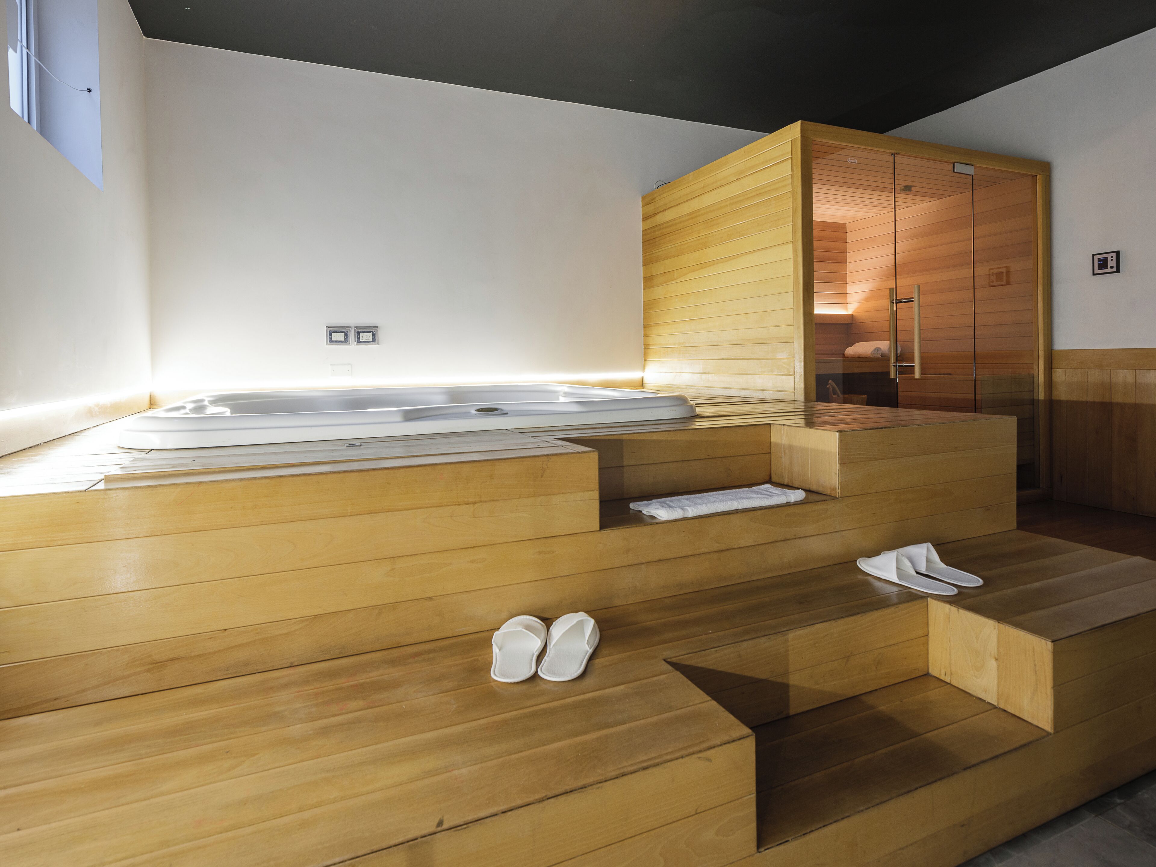 Un sauna avec des bancs en bois et un banc muni d’une serviette.
