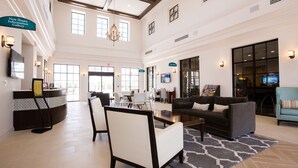 A spacious lobby with a reception desk, seating area, and a large chandelier. - Waterslide, lazy river, private pool, just 7 mi from Disney! (Kissimmee)