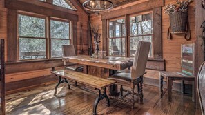 A rustic wooden interior with a dining table, two chairs, and a bench. - Winding Log Ridge- Pet Friendly | Screened Porch | 11 miles from Downtown (Blue Ridge)