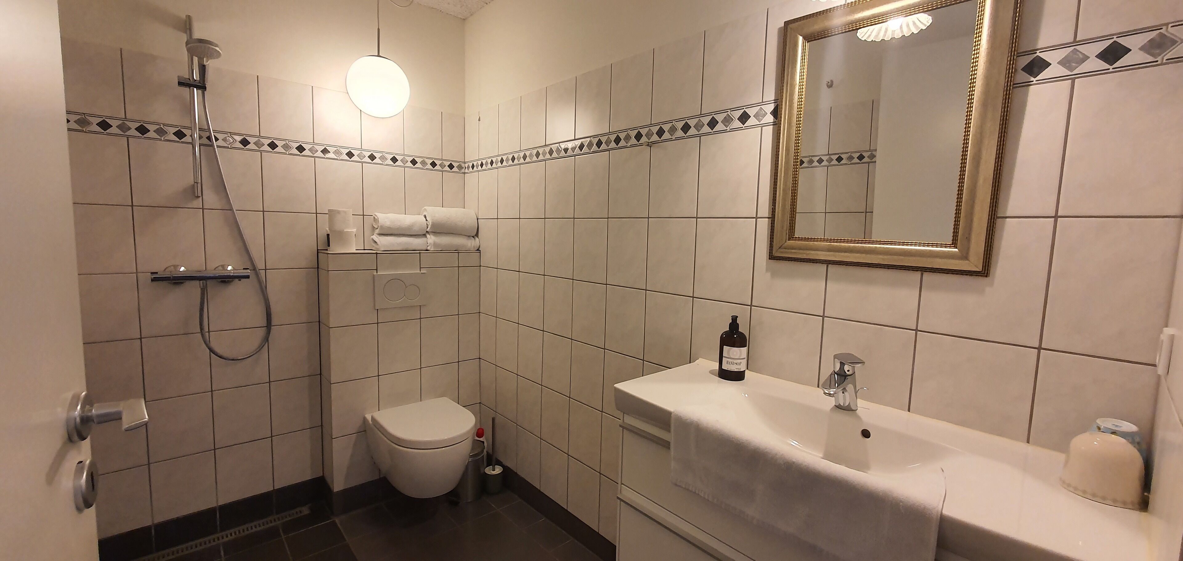 luxury studio suite | bathroom | shower, rainfall showerhead, heated floors, towels