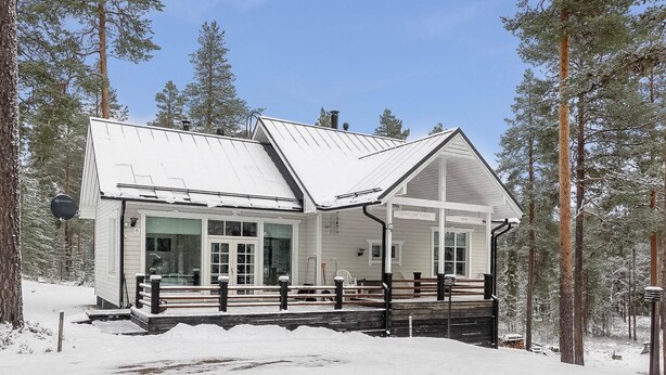 A cabin with a covered porch, surrounded by tall pine trees. - Teppolan rinne by Interhome (Salla)