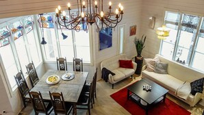 A cozy living room with a dining area, large windows, and a chandelier. - Teppolan rinne by Interhome (Salla)