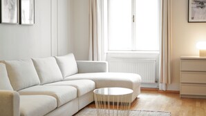 Ein modernes Wohnzimmer mit einem weißen Sofa, einem runden Couchtisch und einer Heizung.